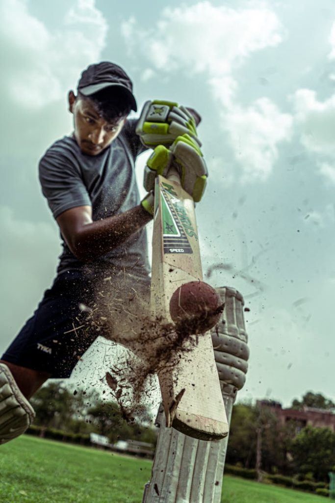 pexels-photo-4747326 A focused cricket player striking a ball with dramatic effect outdoors.